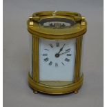 Oval-cased brass carriage clock engraved