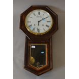 Vaneered wall clock with metal face. Includes pendulum and key.