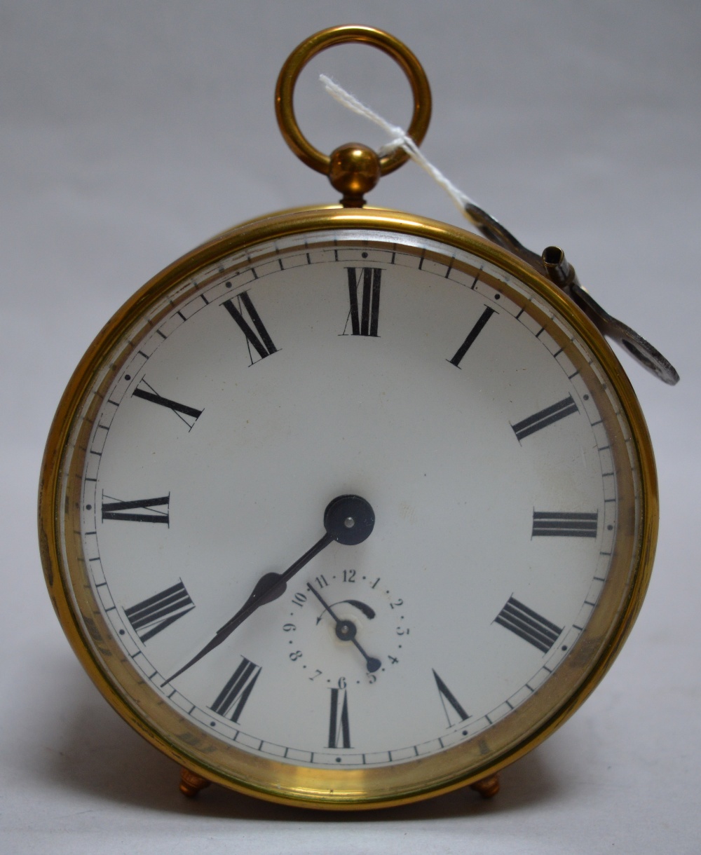 Brass cased, round enamel faced chiming alarm clock, with key. Diameter 9.5cm.