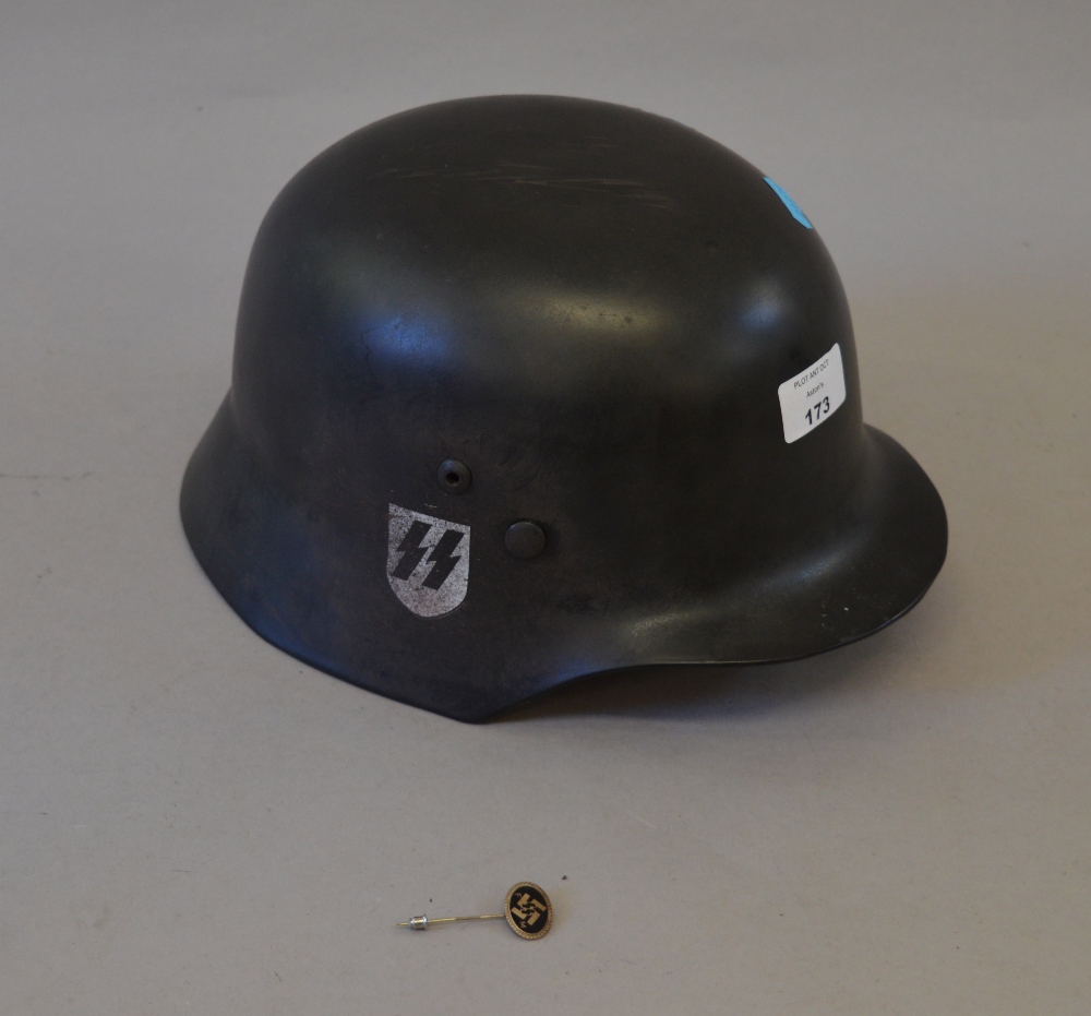 Reproduction German WWII helmet together with a related pin badge (2)