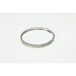 A diamond set hinged bangle, the pavé set stones totalling approx 2.