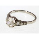 A old cut diamond ring with three diamonds graduating down each shoulder, marked 18k,