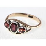 A garnet set three stone ring marked 9ct, approx 1.