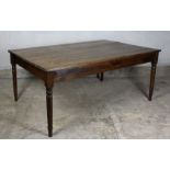 A 19th Century stained pine rectangular kitchen table with seven plank top, plain apron on four