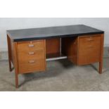 A 1960’s teak finish kneehole desk designed by Herbert Berry for Lucas furniture, with black