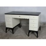 A 1920’s French black and white painted wood kneehole desk of Art Deco design, fitted nine