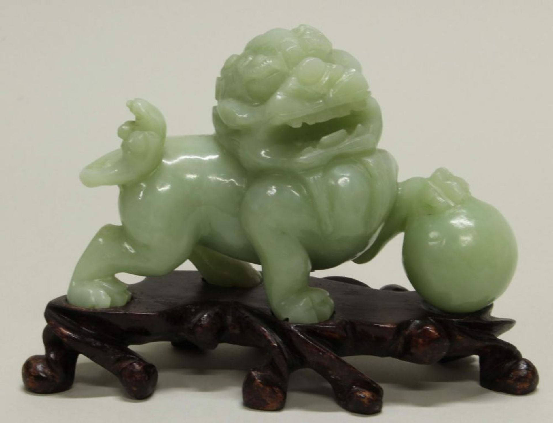 Reserve: 50 EUR        Figur, "Fo-Hund mit Ball", China, 20. Jh., Jadeit, auf Holzsockel, 8.5 cm