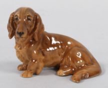Hundefigur Keramik, Keramos, um 1900/20 Sitzender Langhaardackel. Naturalistisch staffiert. Modell