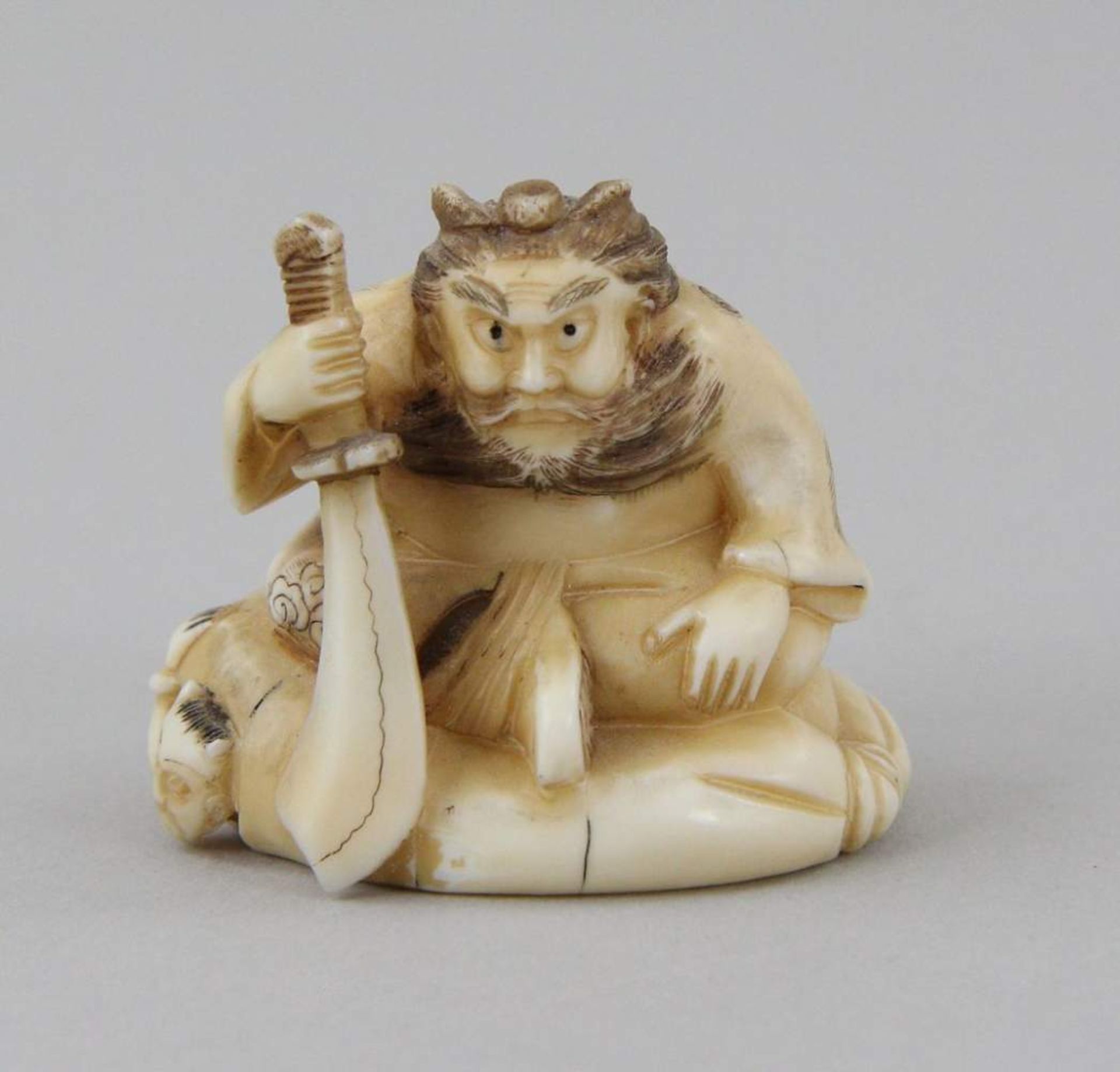 Netsuke "Sh?ki with Oni" Carved and partly coloured walrus tooth, sitting Sh?ki on a large