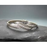 ARMBAND, 585er Weissgold (21,35 g), wellenförmig-durchbrochen gearbeitete Schauseite, besetzt mit 21