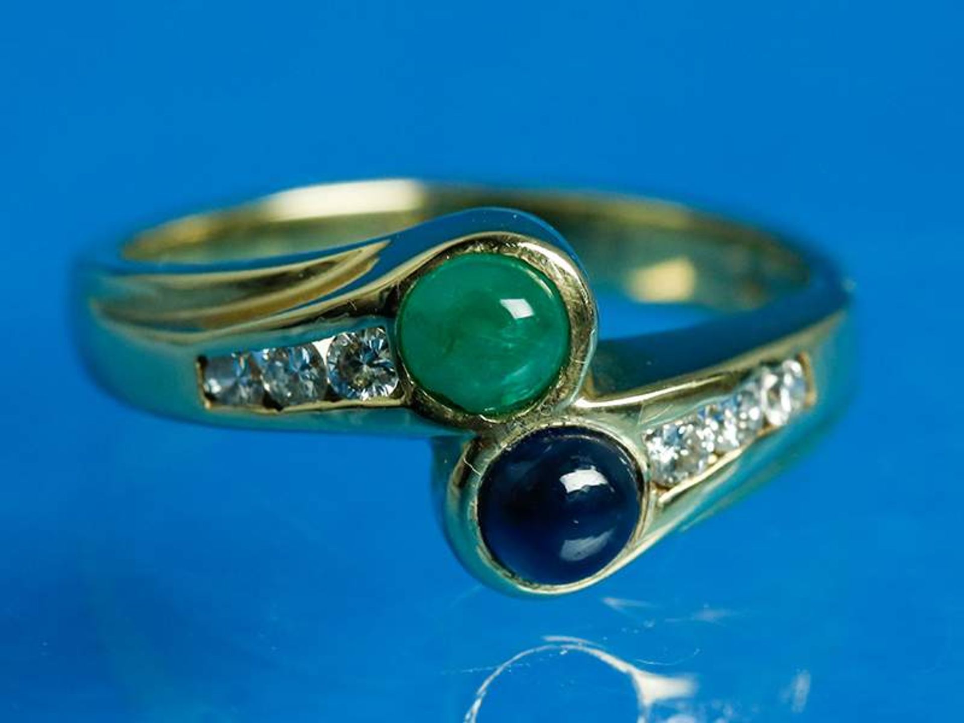 Crossover-Ring mit Smaragd, Saphir und kleinen Brillanten, zusammen ca. 0,18 ct, 20. Jh.
585/-