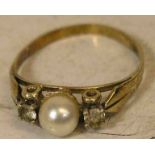 Perlenring. 14 kt. Gold. Ringkopf mit aufgesetzter Perle, flankiert von zwei farblosenSteinen. RG