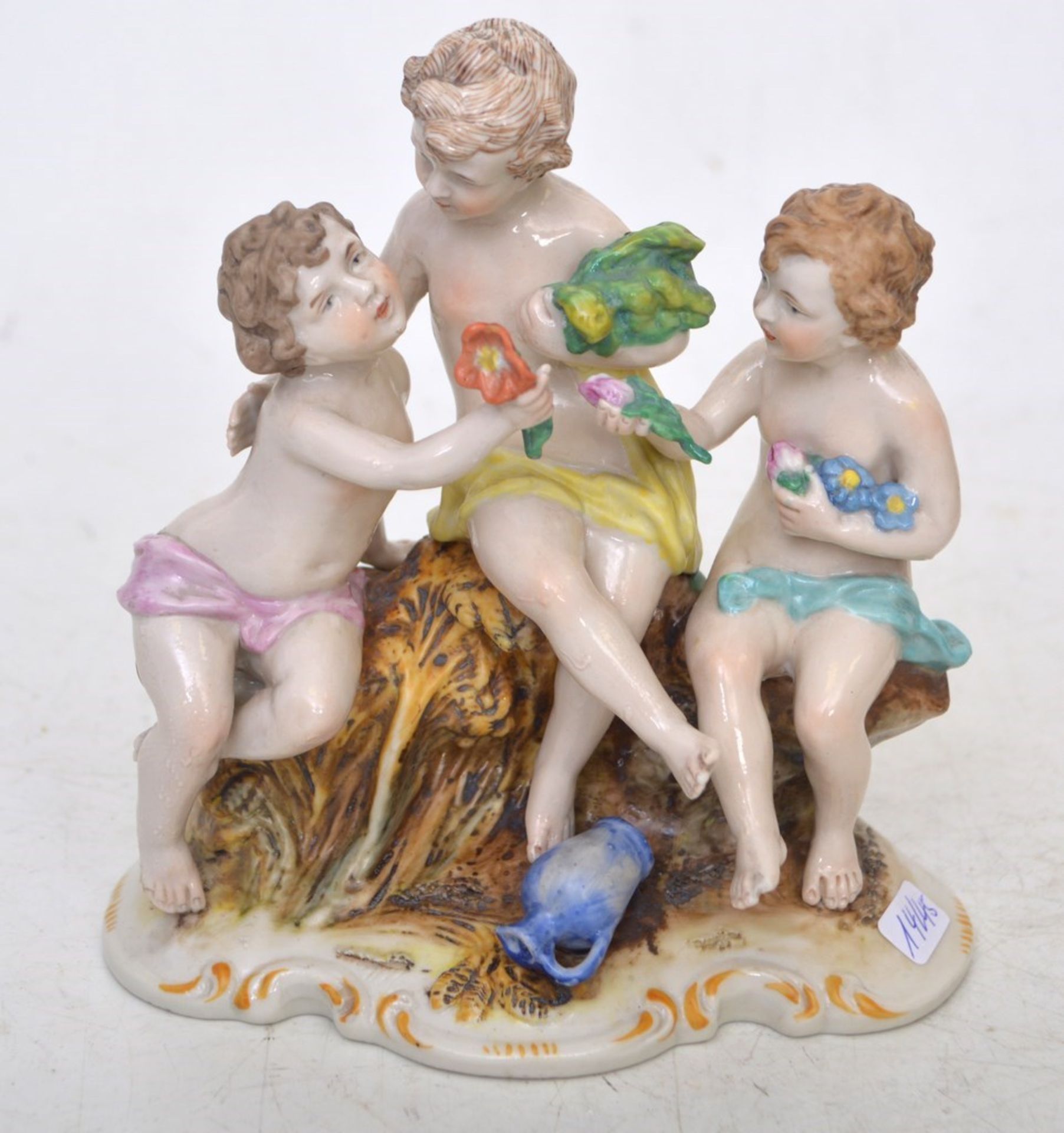 Drei Kinder  auf rechteckigem Sockel sitzend, mit Blumen, bunt bemalt, rechte Figur am Fuß best.,