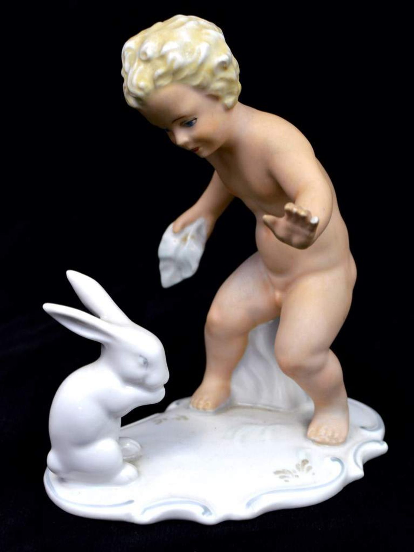 Kind mit Kaninchenauf Rocaillensockel stehender Knabe mit Kaninchen, an der Hand leicht best.,