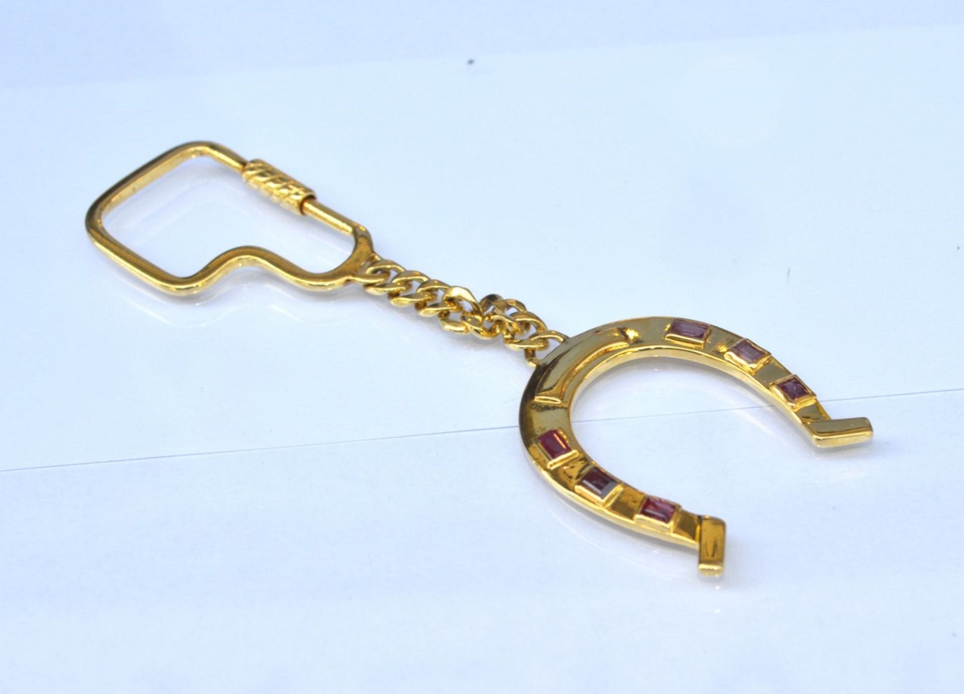 Schlüsselanhänger18 kt. Gelbgold, in Hufeisenform, mit sechs Rubinen im Baguetteschliff, 25,3