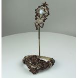 A garnet and silver hair ornament, the centre set with a pale opal with half pearl surround,