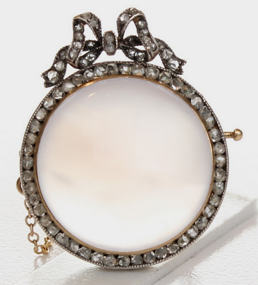 A Beautiful Faberge brooch, set with a moonstone, surrounded by diamonds, with a diamond ribbon to
