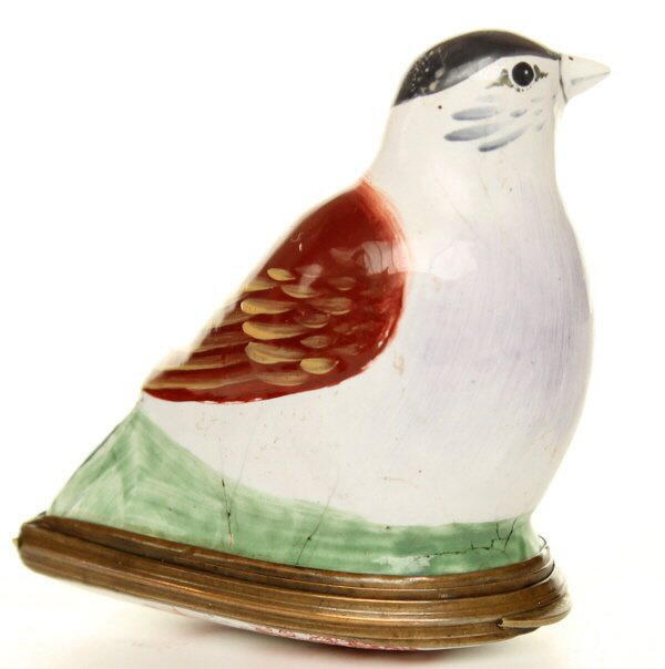 In the form of a bullfinch sitting on a green bunch of reeds the base with a iron red transfer print