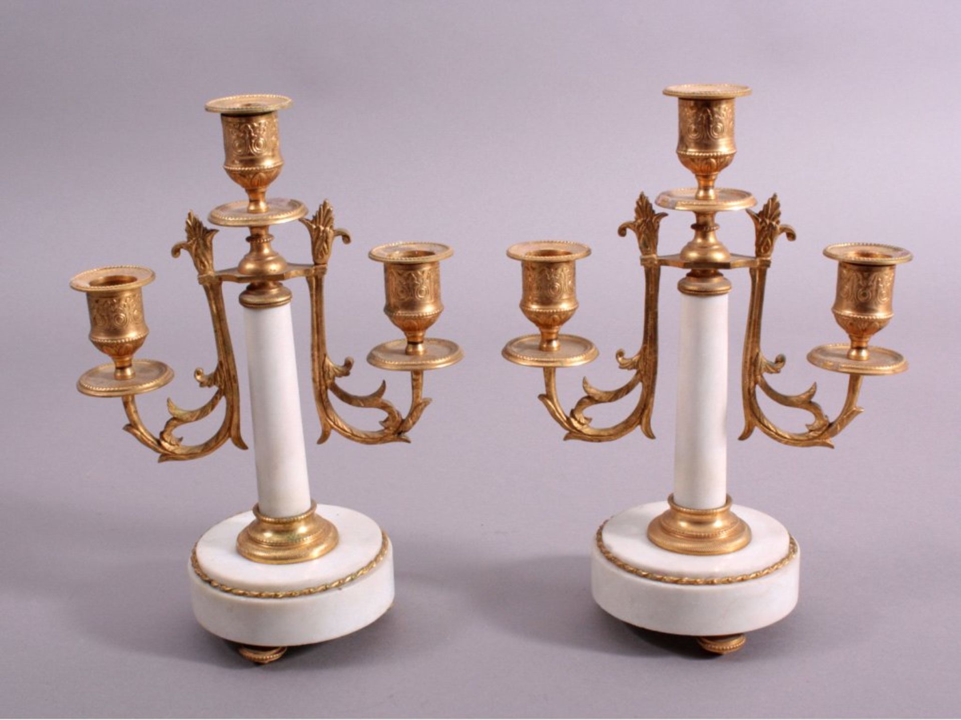 2 Kerzenständer im Empire-Stil3-flammig, Marmor und Messing feuervergoldet, ca. H-26 cmMindestpreis: