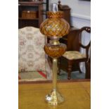 A glass and brass oil lamp, caramel glas