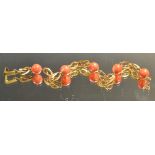 A gold coloured and coral bead bracelet