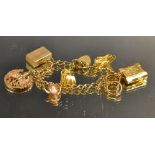 A 9ct gold charm bracelet and charms (22