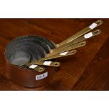 A set of six graduated copper pans with