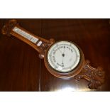 An Edwardian carved oak barometer/thermo