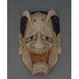 A Japanese ivory netsuke, carved as a gr