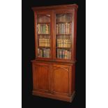 A Victorian Gothic Revival oak library bookcase, moulded cornice above a pair of glazed doors with