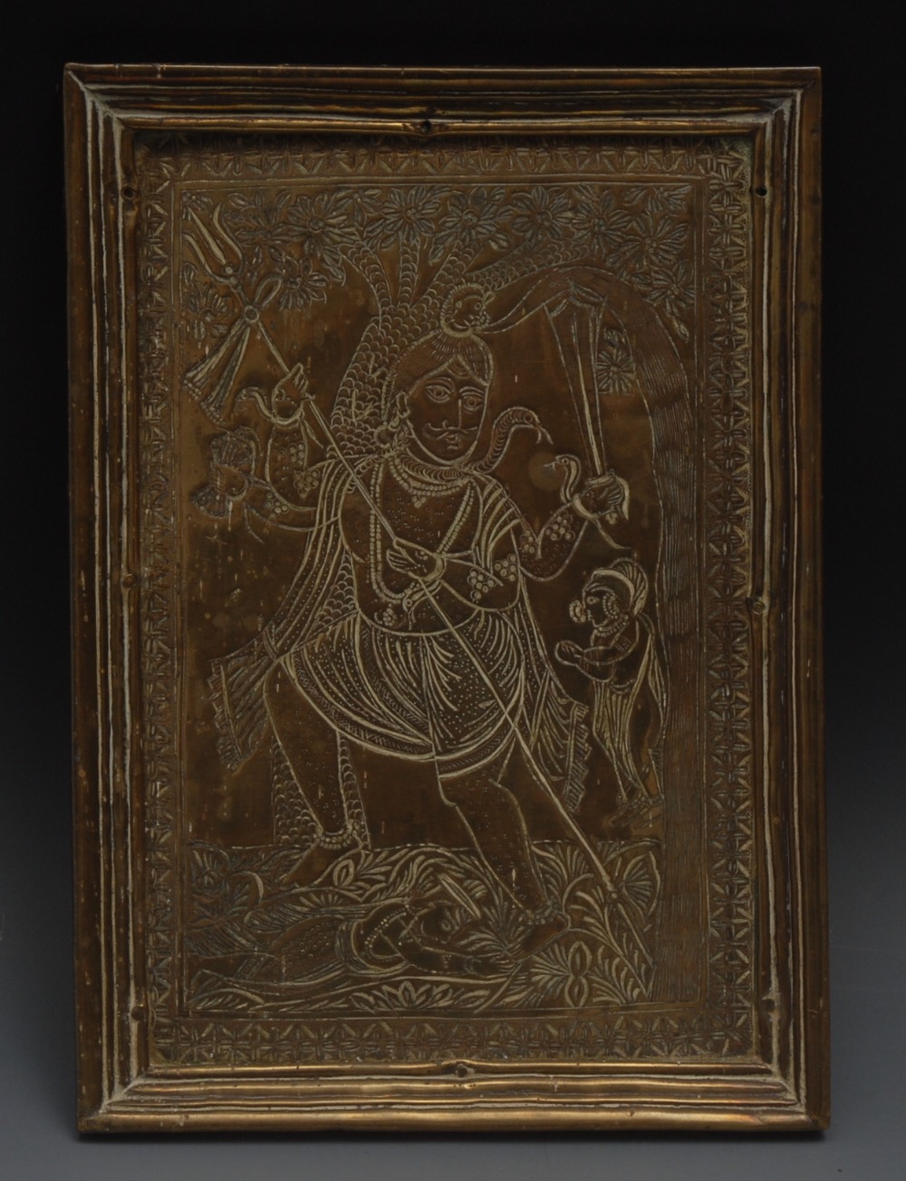 An Indian brass rectangular shrine icon, chased with Hindu god Shiva, he stands, holding a trident