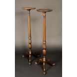 A pair of George III style torchere stands, dished circular tops, tapered fluted acanthus carved