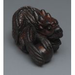 A Japanese hardwood netsuke, carved as a