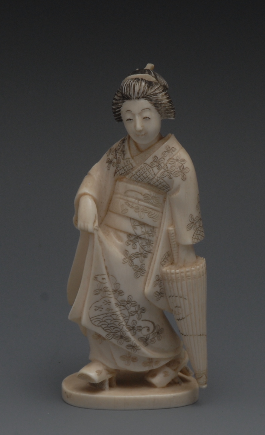 A Japanese ivory okimono of a geisha, sh