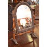 A small Victorian dressing mirror, arched glass, heavily carved frame, turned uprights and