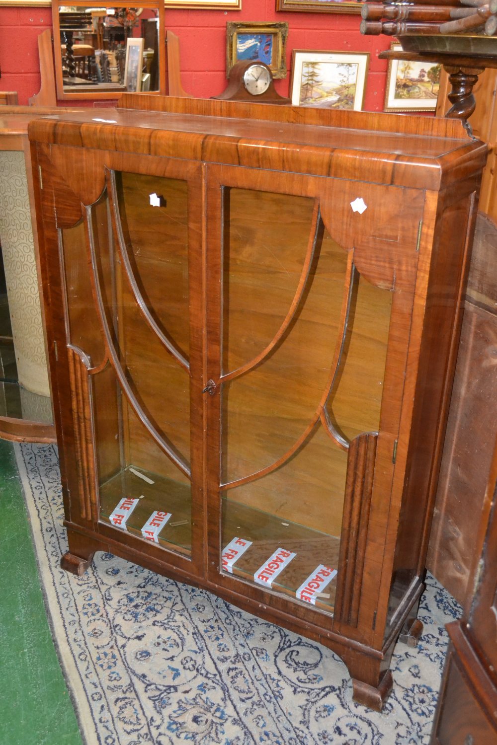 An Art Deco display cabinet, c.1930; a 1940's serpentine fronted display cabinet. (2)
