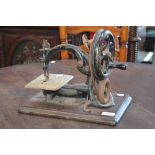 A Wilcox and Gibbs hand-operated sewing machine, wooden plinth base