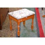 A pine stool with floral upholstered seat