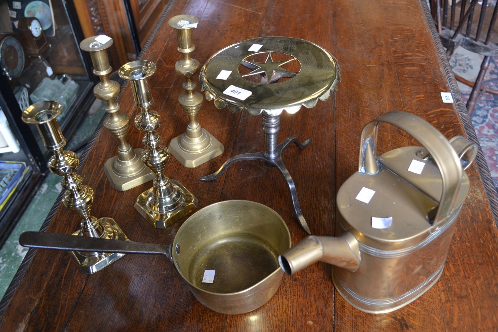 A brass saucepan; a pair of brass candlesticks; another pair, similar; a brass watering can; a