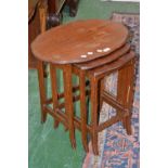 A mahogany nest of three tables, serpentine oval tops.