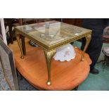 A contemporary gilt wood occasional table, glass top, carved roses in relief, cabriole supports,