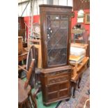 An oak floor standing corner cupboard with glazed leaded light.