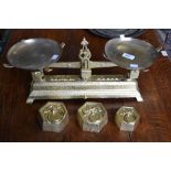 A set of French farmhouse cast iron weighing scales painted gold with two 2kg weights and one 1kg