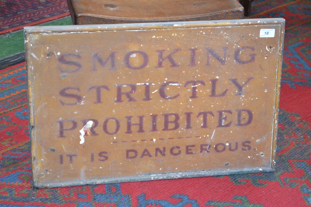 A railway sign, SMOKING IS STRICTLY PROHIBITED IT IS DANGEROUS