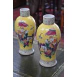 A pair famille jaune vases of baluster form, decorated with scenes of elders.