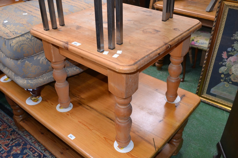 A pine coffee table, rounded square top, turned supports.