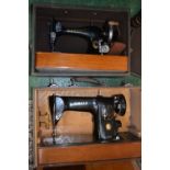 Two Singer sewing machines in carrying cases