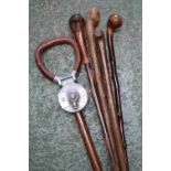 A shooting stick; four walking sticks (5)