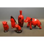 A Royal Doulton flambe elephant, 17cm; a flambe penguin, cat and fox; a flambe vase printed with a