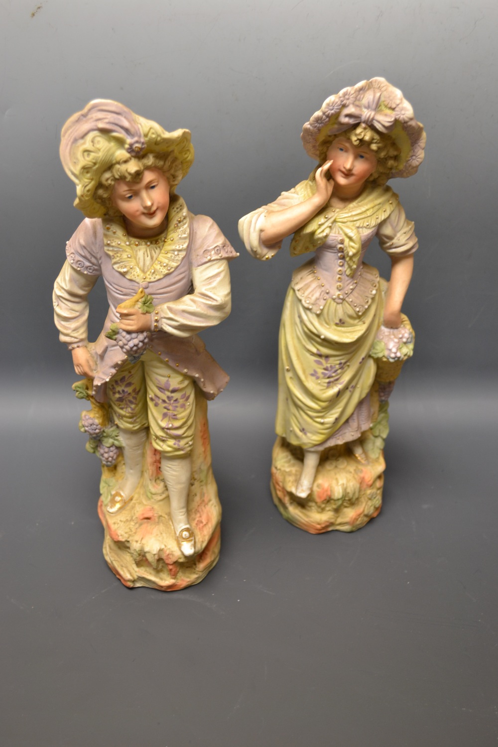 A pair of Continental painted bisque porcelain figures modelled as a grape pickers, Numbered 3365,